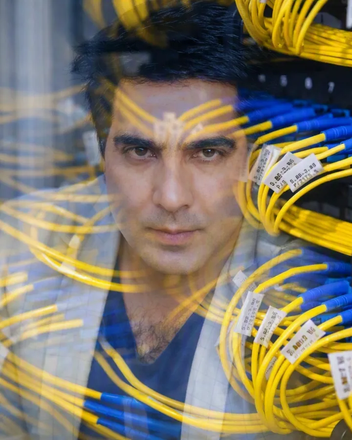 Portrait of Syed Ikram, founder of Aevora Systems, with fibre network cabling
